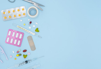 Top view of pills and medical tools on blue background with copy space, medical and healthcare concept. - obrazy, fototapety, plakaty
