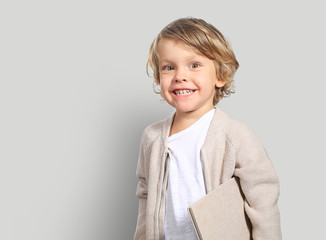 Very cute little boy with a book in his cardigan