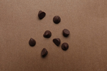 Fototapeta na wymiar Delicious chocolate chips on brown background, top view