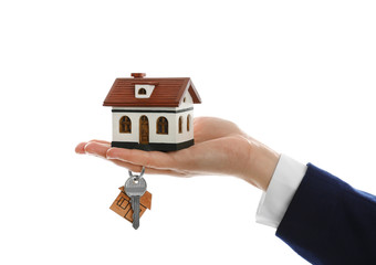 Real estate agent holding house model and key on white background, closeup