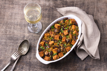 Vegan Stuffing with Mushrooms, Leeks and crunchy croutons on wooden table, top view. Thanksgiving traditional meal	
