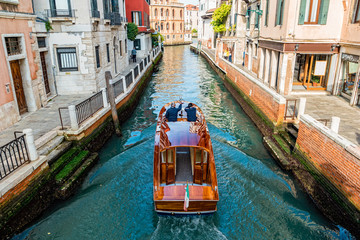 Fototapeta na wymiar Water taxi on canal street in Venice, Italy