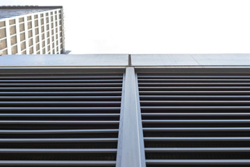 Tall building is shot from below. Blue sky and skyscraper and copy space. Horizontal and vertical lines as part of a multi-story building