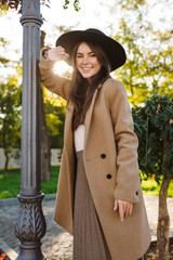 Portrait of satisfied woman smiling while walking in green garden outdoors