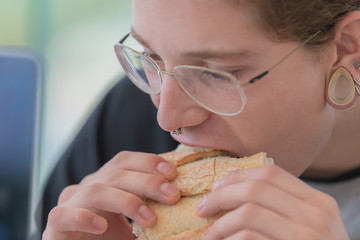 Young man who is eating a sandwich