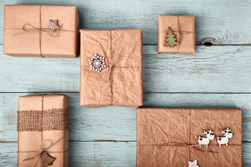 Christmas gift boxes wrapped in kraft paper on blue wooden table. Zero waste, eco friendly...