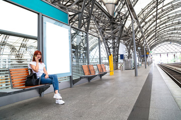 Traveler girl sitting on wooden bench on station