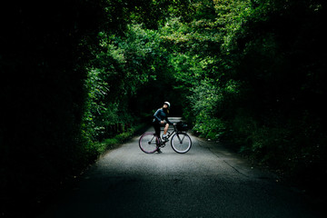 Young girl with her bicycle in a forestal road