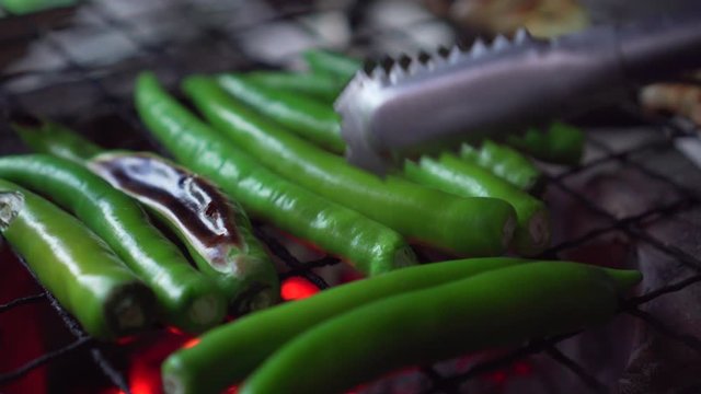 Green bell pepper getting grill on charcoal grill. hot fire under. flip it.