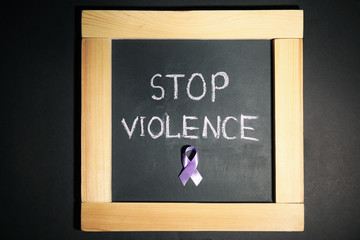 Chalkboard with purple ribbon and phrase STOP VIOLENCE on black background, top view
