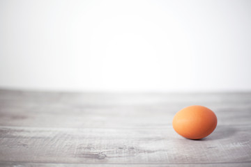 Whole brown egg solitary on gray wooden background