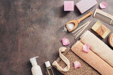 Plakat Flat lay a set of various bath and spa accessories. Terry towel, soap, comb, oil, shampoo, loofah washcloth, sea salt on a dark rustic background. Top view, flat lay, copy space.