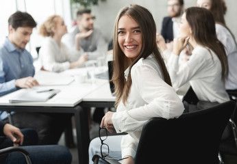Happy business lady smiling to camera during meeting