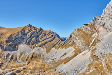 Rocky mountains covered with autumn meadow against the blue sky