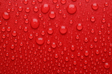Fototapeta premium Water drops on red background, top view