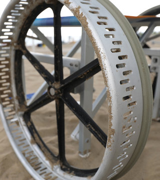 big wheel of a special wheelchair to move in the sand of the bea