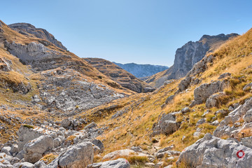 Rocky mountains covered with autumn meadow against the blue sky
