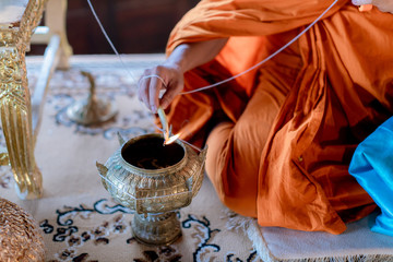 Buddha monk hold candlestick above holy water bowl. religion ceremony. Buddhist holy water. image for copy space.