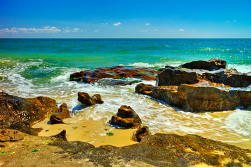 Fototapeta na wymiar Beautiful landscape with rocks and sea waves on a sunny beach