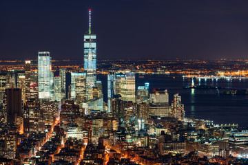 Obraz premium Aerial night view of the Financial District of New York City. View of World Trade Center skyscrapers and New York Harbor. Lower Manhattan, NY, USA