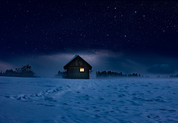 Gemütliche Holzhütte in einer Winternacht