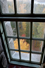 A view to an autumnal forest from an old window.