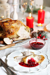 Fototapeta na wymiar pieces of turkey with cranberry sauce on a plate on Christmas Day. turkey for Christmas. New Year's and Christmas table with turkey in white tones.