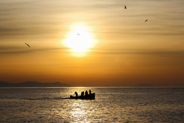 Fototapeta na wymiar fishing boat and seagulls on sunrise background during sunrise over the baltic sea in gdynia, poland