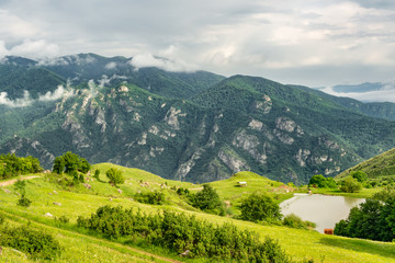 Fototapeta na wymiar Small lake at the bottom of a mountain in summer