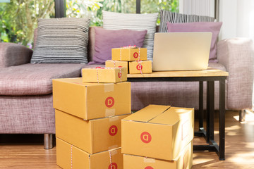 Cardboard parcel box and laptop ondesk at workplace of startup small business owner for online selling.