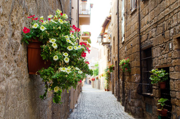 Fototapeta na wymiar A medieval italian street in Orvieto with flowers
