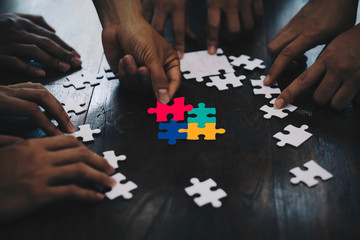 Closeup hand of business people connecting jigsaw puzzle with sunlight effect, Business solutions...