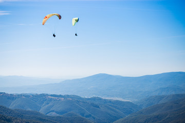Paragliding group in air sport on top of a mountain. The whole world is in sight. Like a bird, out of gravity