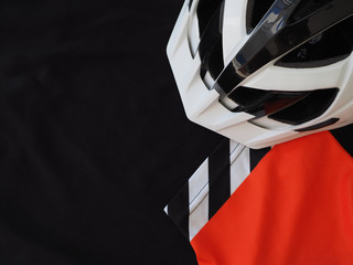 Black men's jersey and white bicycle helmet. sport accessories, sport equipment. Top view. Place for text.