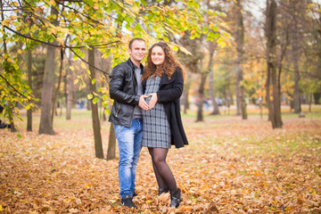 Naklejka na ściany i meble Happy pregnant couple in autumn background