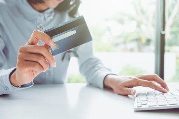 Fototapeta premium asian young business hands holding credit card and using laptop smart phone Online shopping Website,Article, Blog.Easy Ecommerce Website Shop Online by Smartphone.Online shopping concept