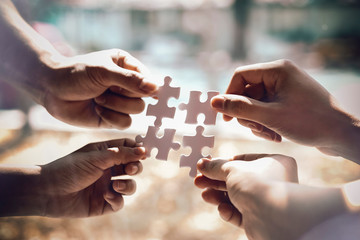Closeup hand of business people connecting jigsaw puzzle with sunlight effect, Business solutions...