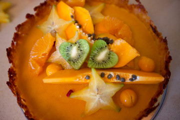 Fototapeta na wymiar Cake with fresh fruits kiwi dragon fruit papaya carambola