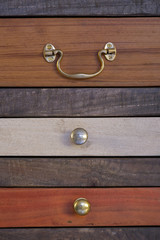 Old chest of drawers in different colors with drawers and different door handles