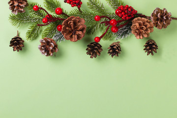 Christmas fir branch with cones on a green background, with Xmas toys. Copy space, mockup