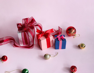 Three gift boxes on light pink background.