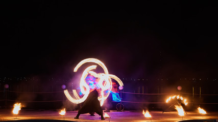 Artists juggling with burning poi's at fire performance.
