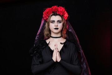 girl witch in a wreath of red roses - 303903925