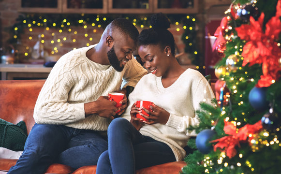 Black couple celebrating Christmas together, reading coffee grounds for fun