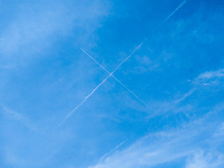 Two crossing traces from planes in clean blue sky