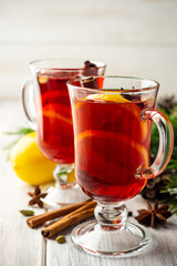 Christmas mulled wine with spices and lemon on wooden rustic background. Selective focus.
