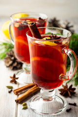 Christmas mulled wine with spices and lemon on wooden rustic background. Selective focus.