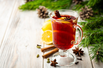 Christmas mulled wine with spices and lemon on wooden rustic background. Selective focus.