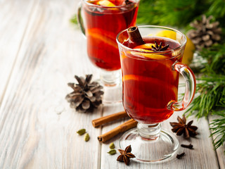 Christmas mulled wine with spices and lemon on wooden rustic background. Selective focus.
