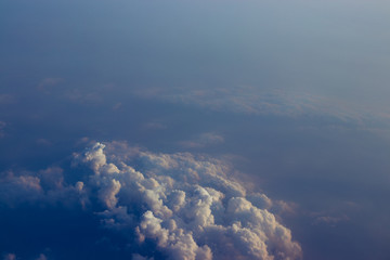 Fototapeta premium Aerial view sunset sky above clouds with dramatic light. View from airplane